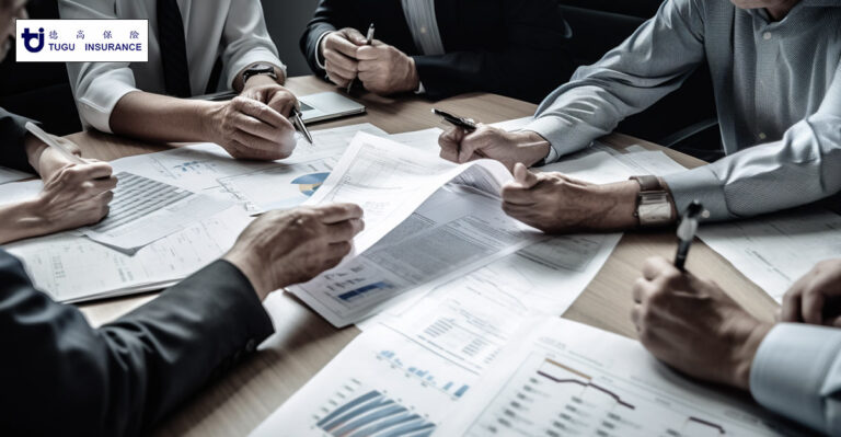 Photo of people in a meeting reviewing financial information. Tugu Insurnace logo in the top left corner.