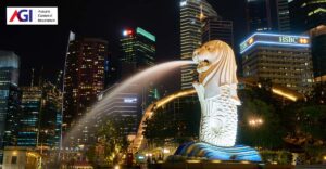 Photo of Merlion in Singapore at night with city buildings in background. AGI logo in top left corner.