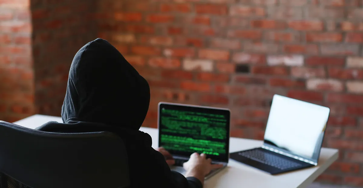 Photo of person with hoodie hacking.