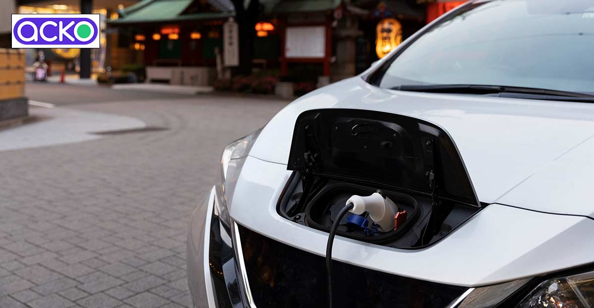 Photo of electric car charging. Acko logo in top left.