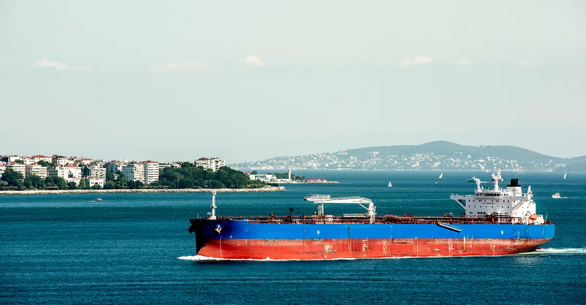 Photo of oil tanker with blue and red colours in ocean.