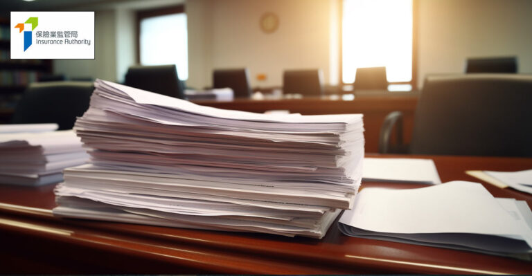 Photo of a huge pile of paperwork on desk. Hong Kong InsuranceAuthority logo in top left.