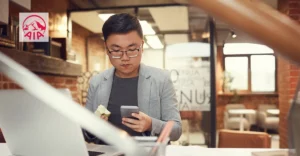 A photo of man in Hong Kong coffee shop looking at his phone. AIA logo in top left corner.