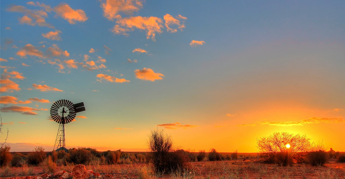 A photo of Sunrise in Australian outback. logo in top left corner.