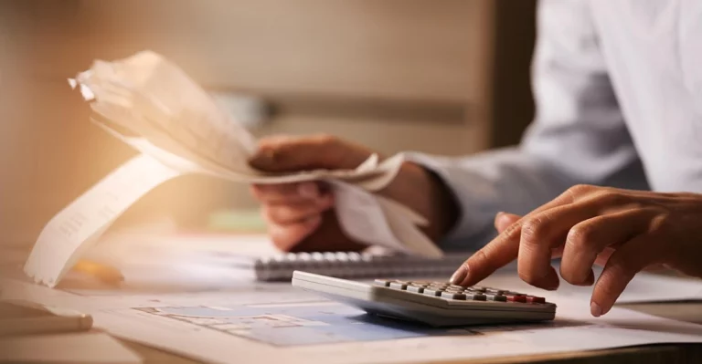 A photo of someone calculating the value of something using a calculator.