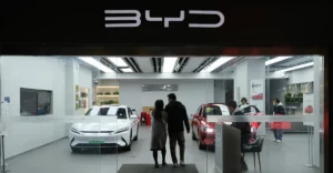 A photo of a BYD dealership with a couple walking in.