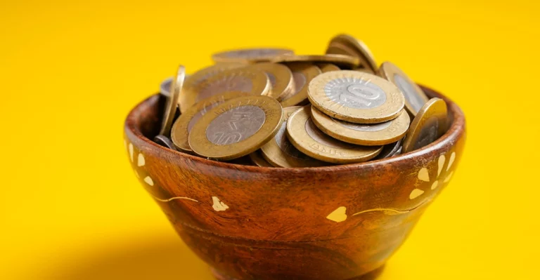 A photo of Indian rupee coins in a bowl.