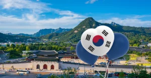 A photo of Korea in background and balloons with Korean flag in foreground.