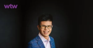 Drian Chua smiling in front of a black background.