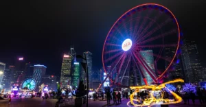 A ferris wheel in the middle of a city at night.