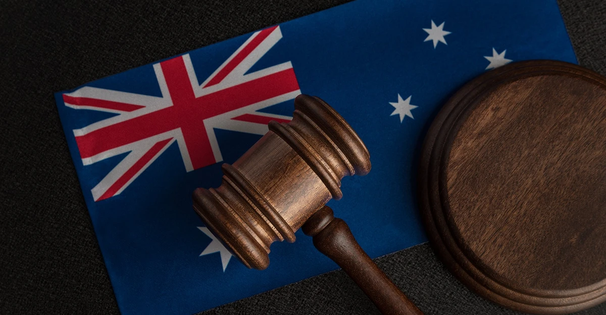 A wooden gavel sits on top of an australian flag.