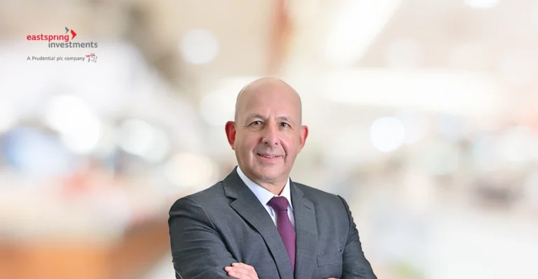 A bald man in a suit and tie is posing for a photo.