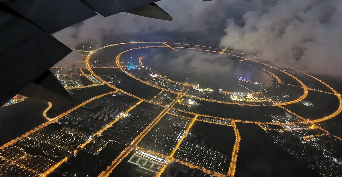 An airplane flying over a city at night.