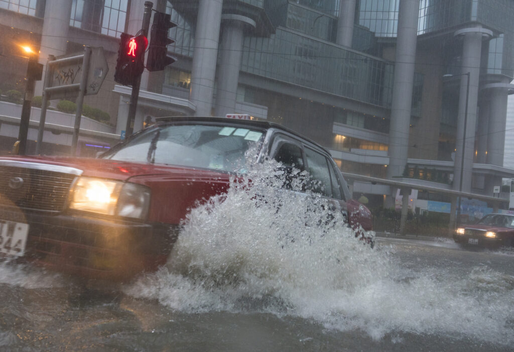 A car driving through a flooded street.