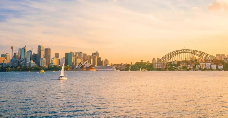 The sydney opera house and sydney harbour bridge at sunset.