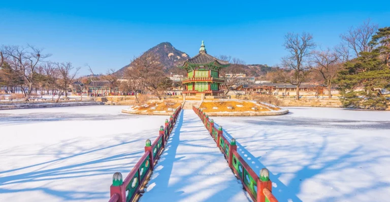 A pagoda in the snow with a mountain in the background.