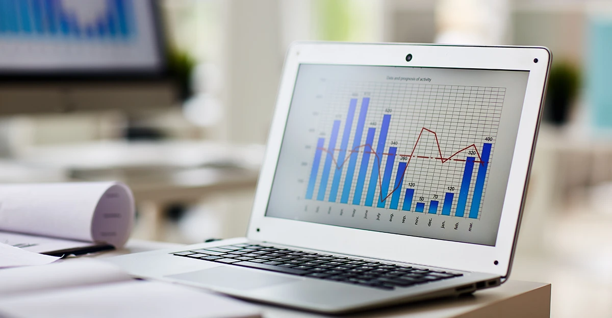 A laptop with graphs on it on a desk.