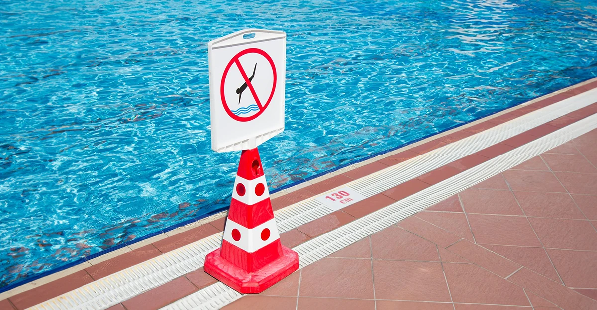 A no swimming sign in front of a swimming pool.