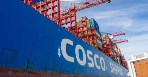 A blue container ship docked at a dock.