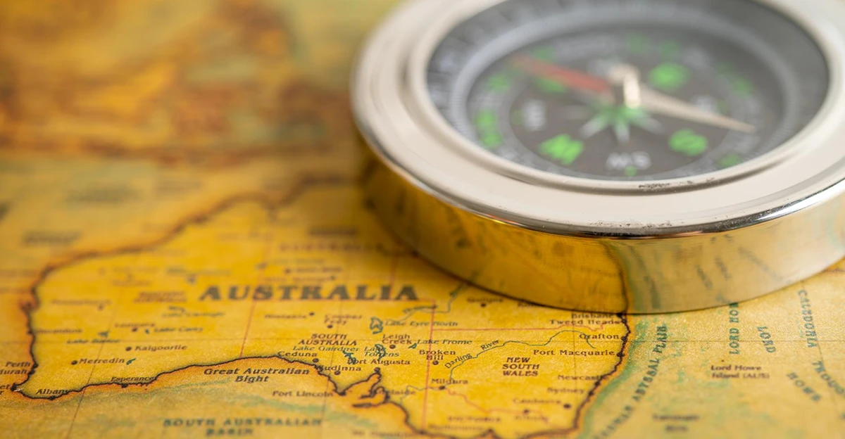 A compass sits on top of a map of australia.