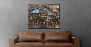 An abstract painting of umbrellas hanging above a leather couch.