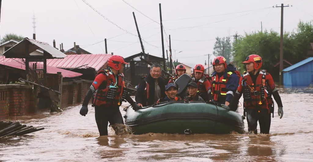 A group of people in a raft on a flooded street.