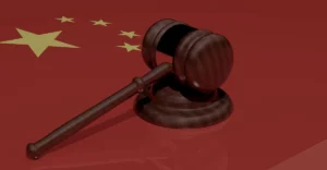 A wooden gavel on top of a chinese flag.