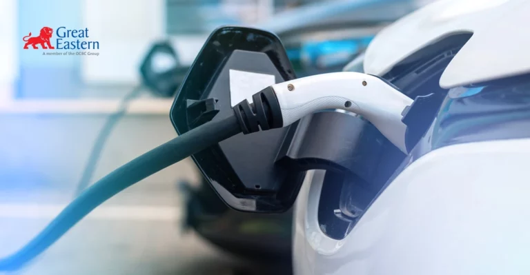 A white car is plugged into an electric charger.