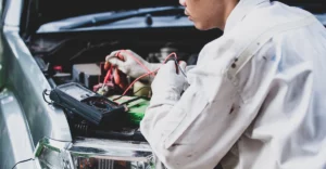 A mechanic is working on a car's engine.