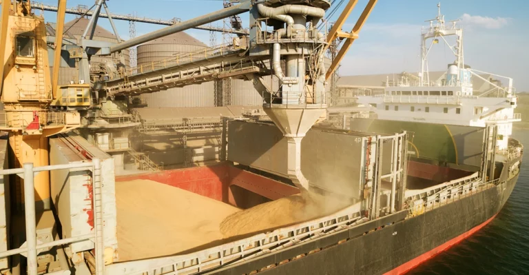 A ship is loading sand onto a ship.