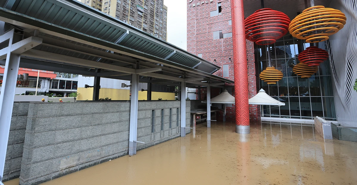 A flooded area near a building with colorful lanterns.