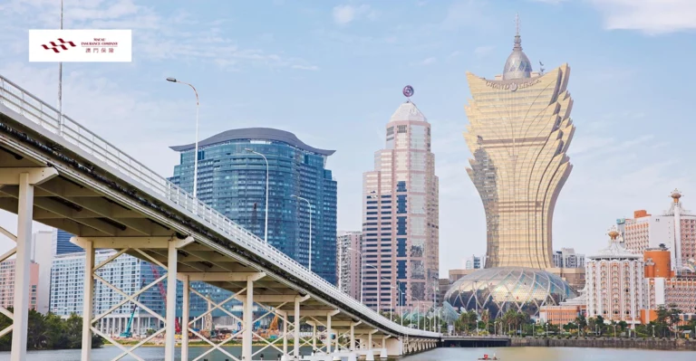 A bridge over a body of water with a large skyscraper in the background.