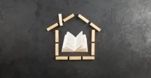 A book is shaped like a house on a black background.