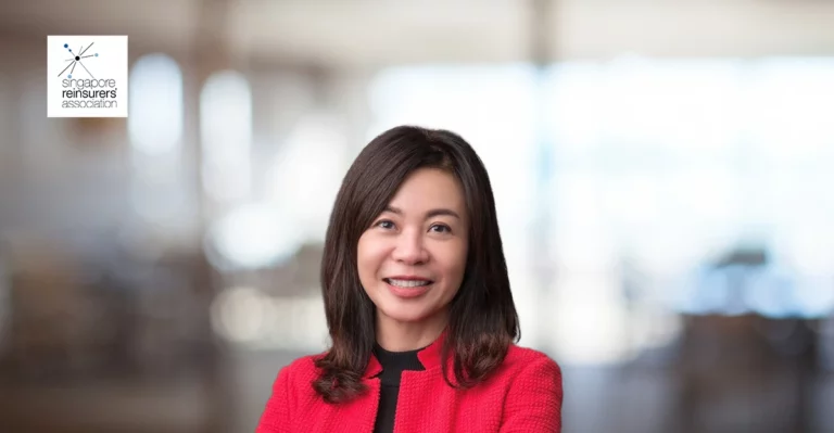 A woman in a red jacket smiling for the camera.