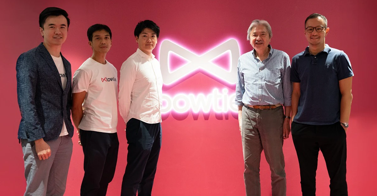 A group of men standing in front of a pink wall.