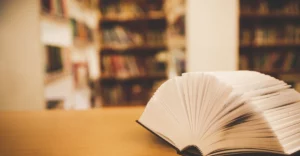 An open book on a table in a library.