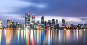 A city skyline is reflected in a body of water.