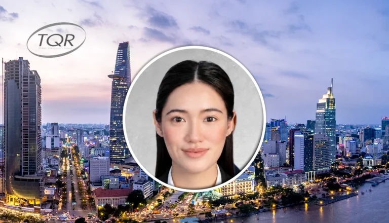 Smiling woman portrait overlaid on a city skyline at dusk with a TQR logo.