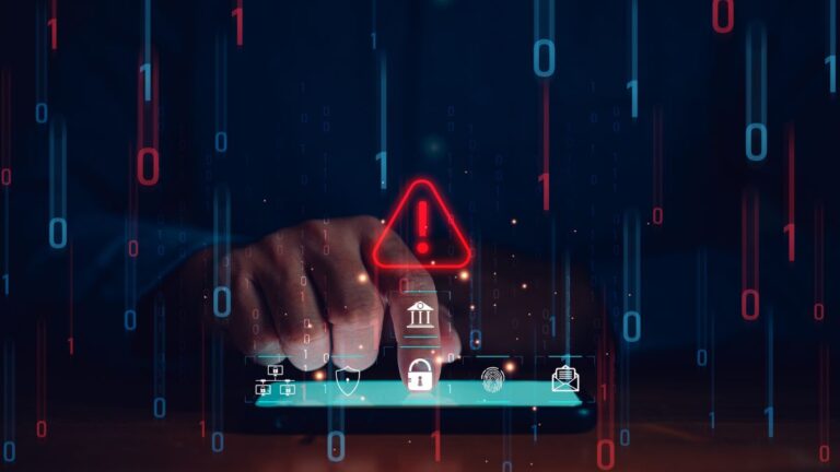 Close-up of a hand tapping a tablet with a glowing red warning triangle, symbolizing a cybersecurity alert.