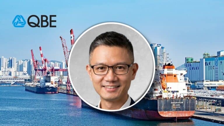QBE logo over a port with cranes and cargo ships, with a circular portrait of a smiling man wearing glasses superimposed in the center