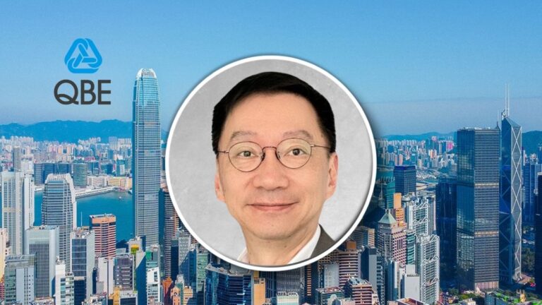 City skyline with the QBE logo on the left and a circular portrait of a smiling man in the center demarcated by a white circle.