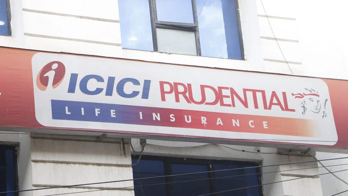 Signboard says ICICI PRUDENTIAL LIFE INSURANCE on a white banner with a blue–orange gradient and logo.