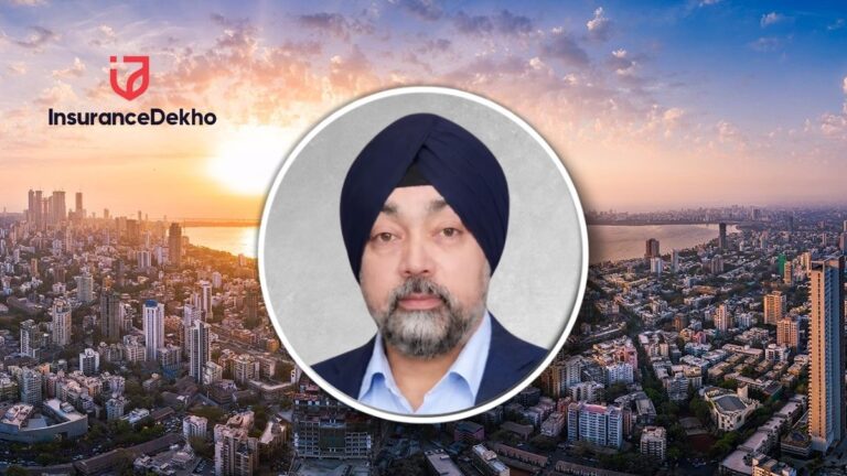 Circular portrait of a man wearing a navy turban and blazer, placed over a city skyline at sunset with InsuranceDekho logo in the corner.