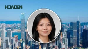 City skyline with blue sky and the HOWDEN logo, overlaid by a circular portrait of an Asian woman in the foreground.