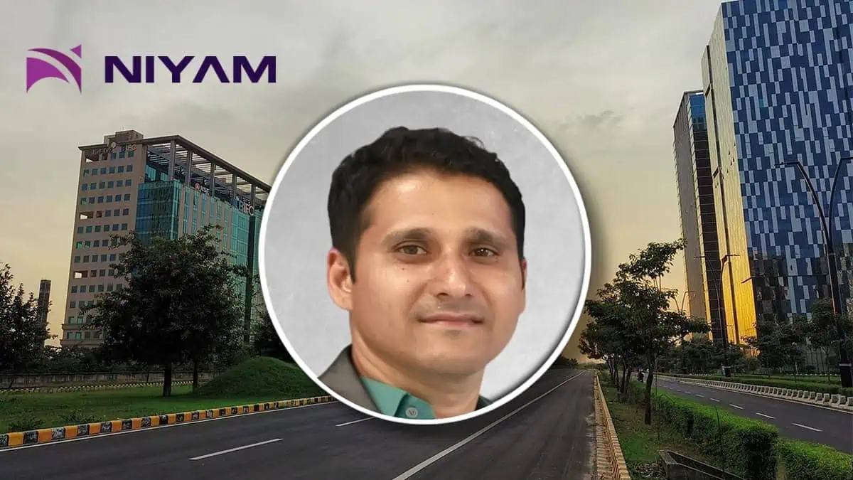 Circular headshot of a smiling man over a city street backdrop with the NIYAM logo in the top-left corner.