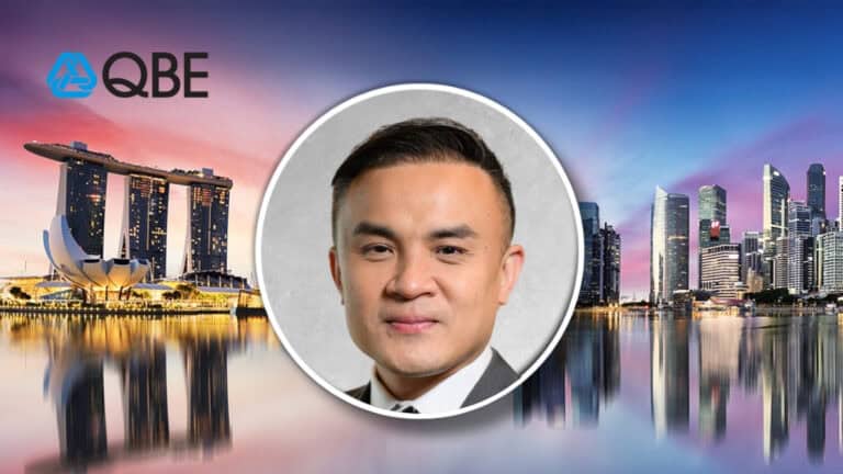 QBE logo on the left, Singapore skyline at sunset, with a circular headshot of a man centered on a gray background.