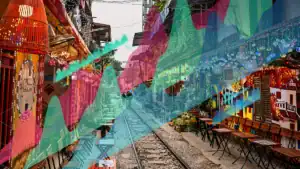 Vibrant street cafe scene with train tracks down the center, colorful translucent overlays in teal, pink and green.