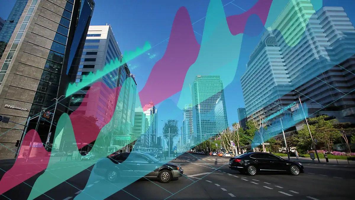 Busy city street with tall glass buildings and a translucent multicolored chart overlay representing data analytics.