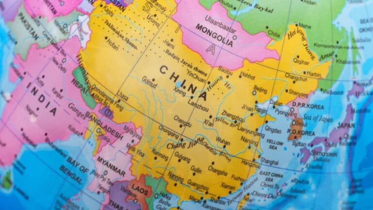 Map showing China in yellow surrounded by neighboring countries in pink and purple, including India, Mongolia, Korea, and Japan on a globe-like projection