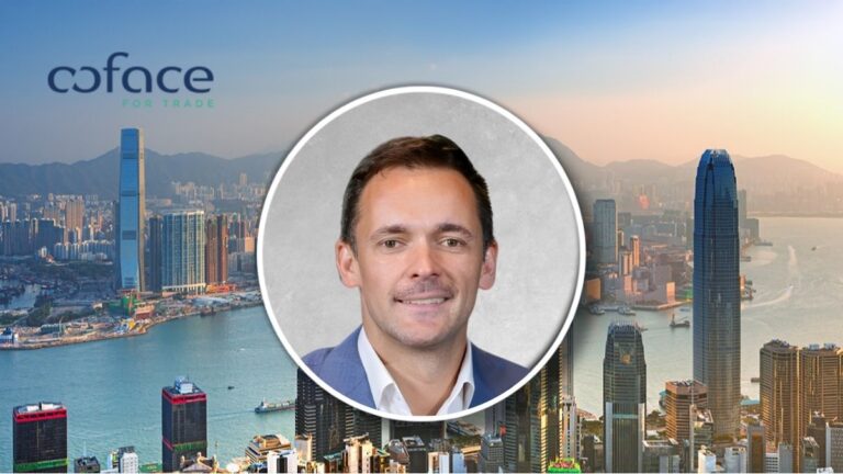 Portrait of a smiling man in a blue suit over a city skyline with the Coface for Trade logo in the top left.